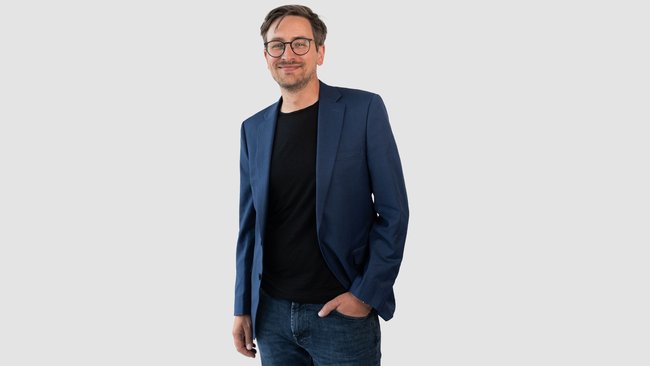 A portrait of Jörg Pieper, CEO of abat AG, in front of a white wall.