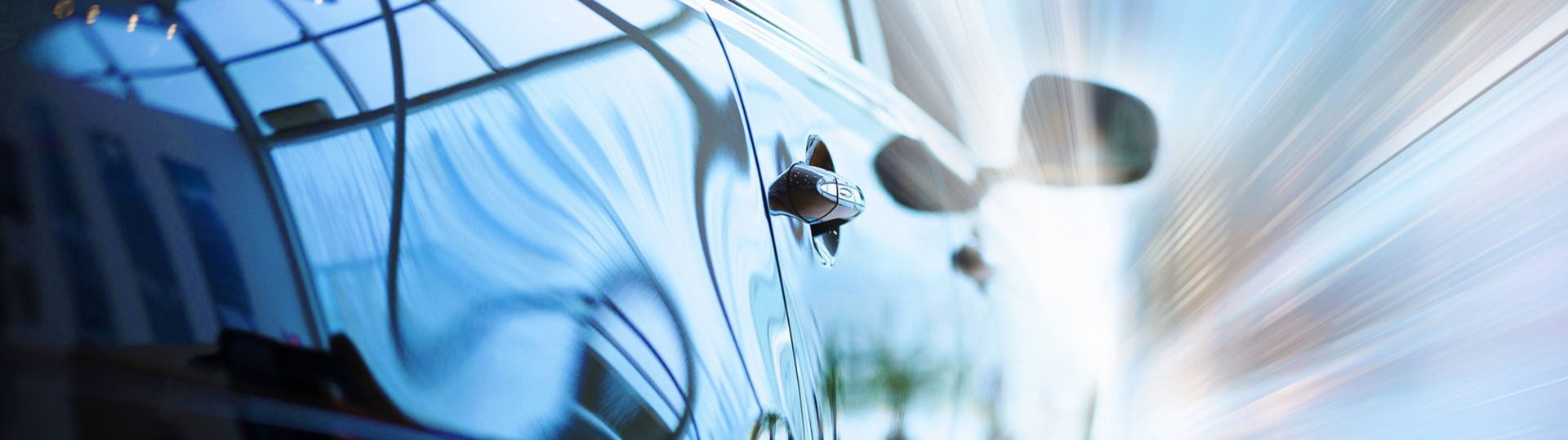 Close-up of a shiny car with a reflective surface showing speed through light effects.