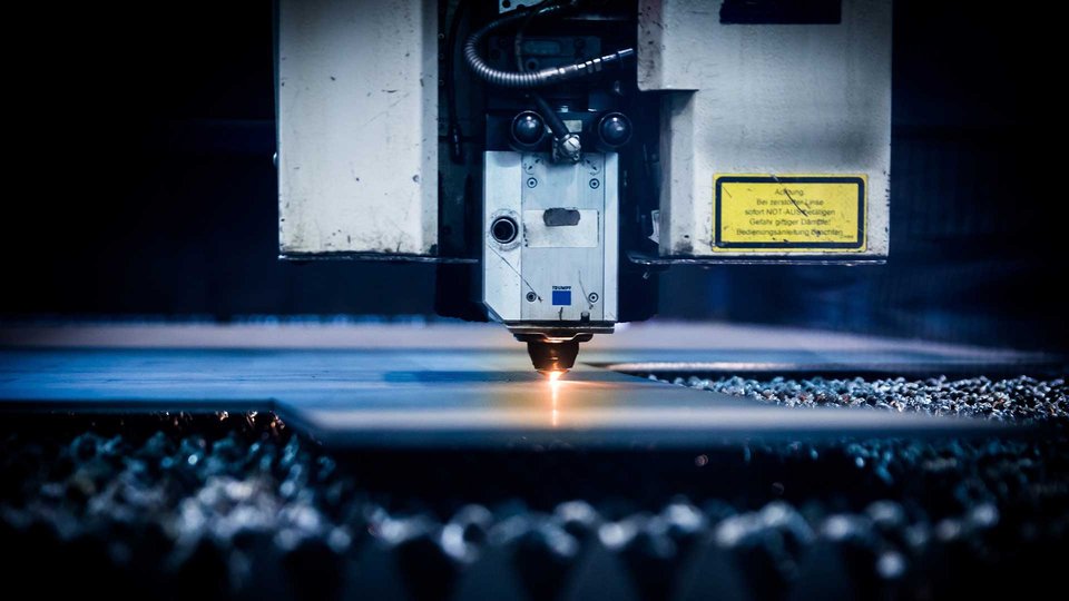A Close-up picture of a CNC laser cutting machine cutting a metal plate.