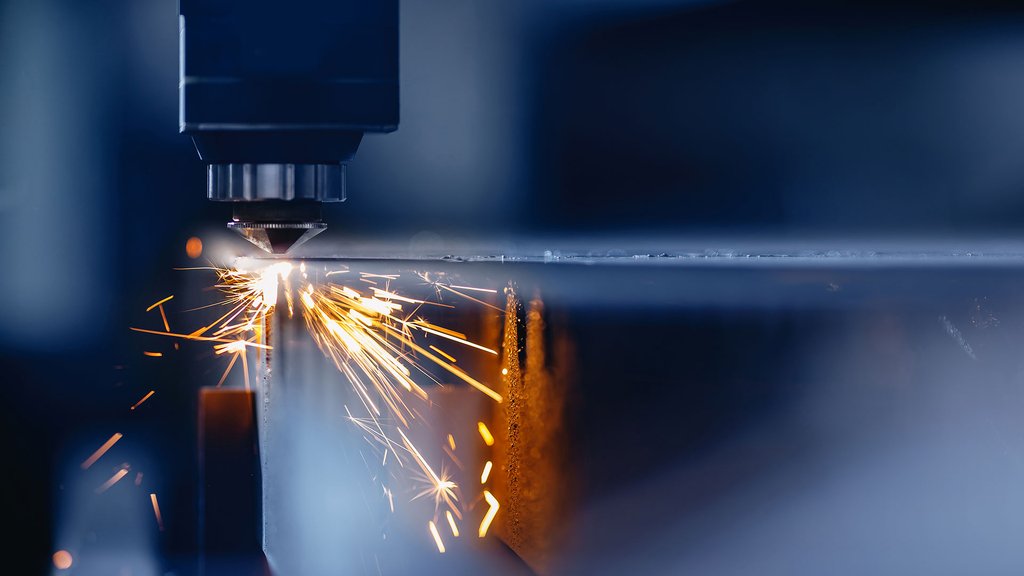 Laser cutting machine precisely cuts sheet metal, sparks fly in modern manufacturing.