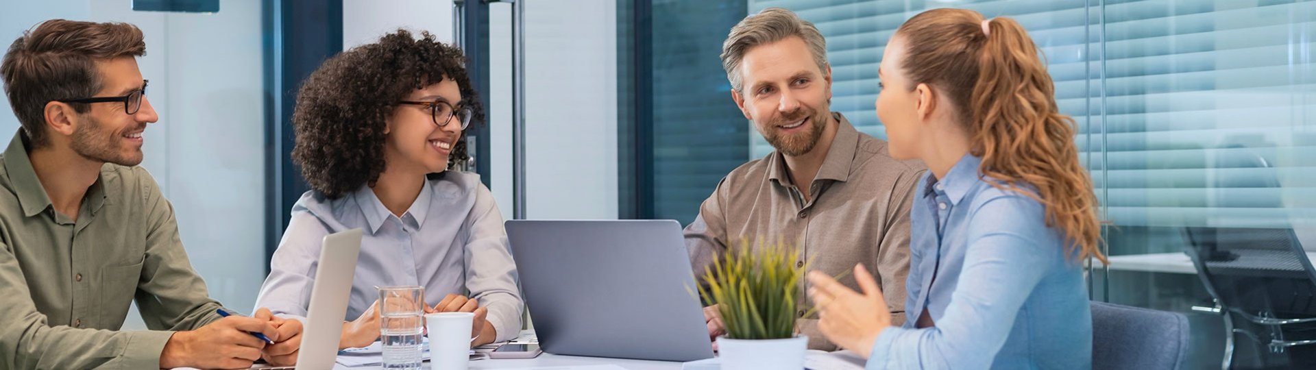 abat employees in discussion during a team meeting in a modern office setting.