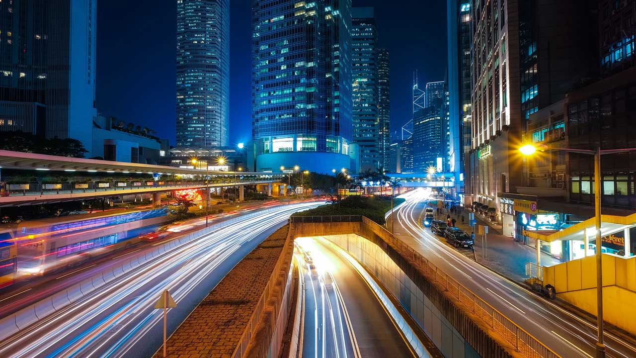 A pcture of long exposure of a busy city at night with some traces of traffic.